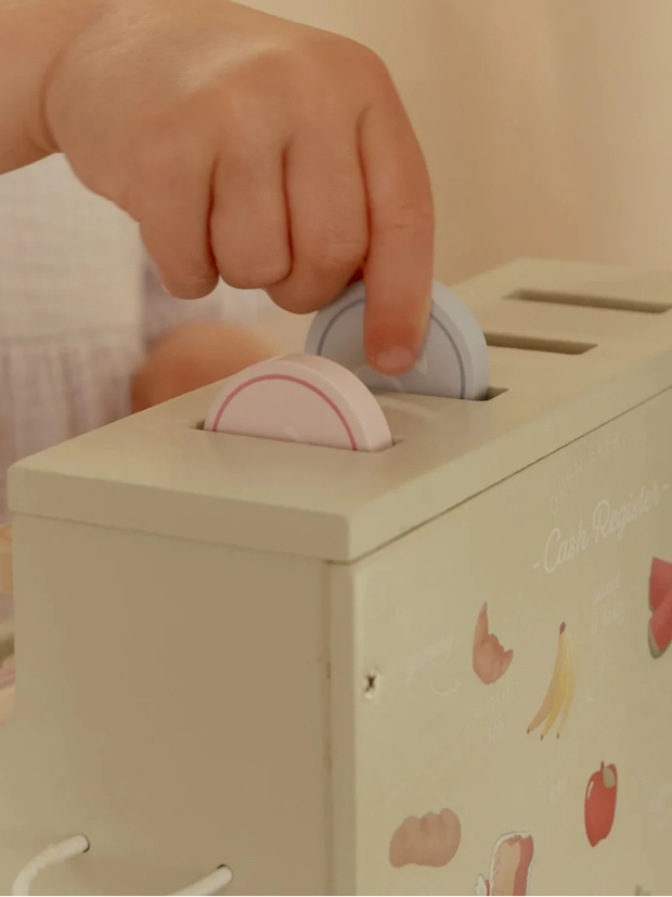 Child playing with Little Dutch Wooden Cash Register Toy for Kids, inserting coins into the cash register's slot.